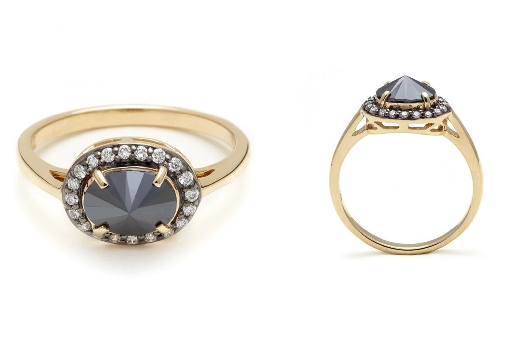 Yellow gold ring with oval black diamond in the centre flanked by a halo of smaller white diamonds.