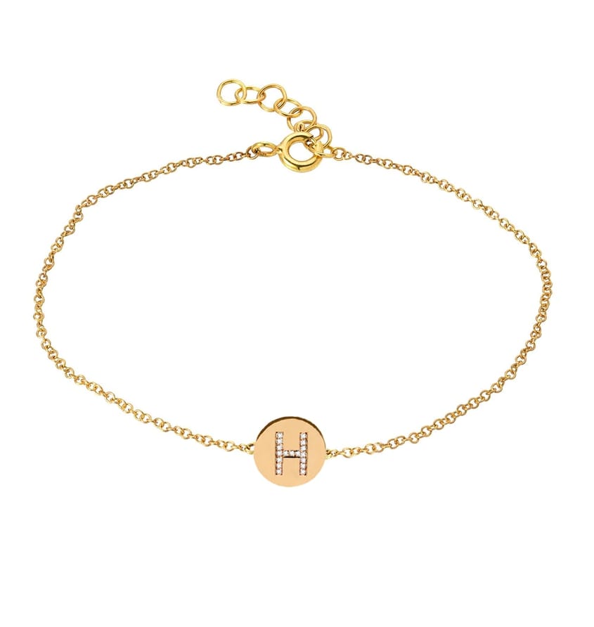 Chain bracelet with the letter H studded with white diamonds on a yellow gold disc.