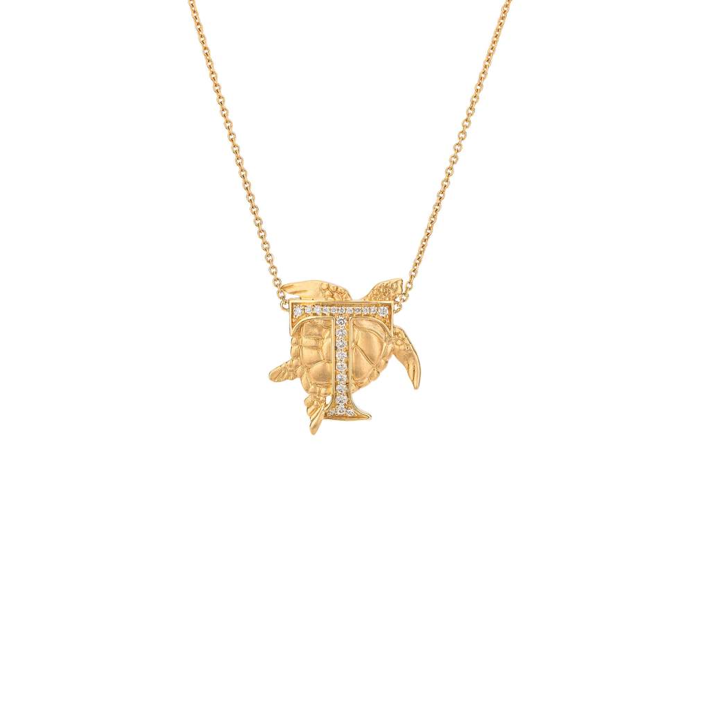 Diamond letter T necklace with a gold sculpted turtle necklace.